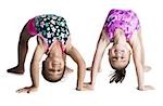 Young female gymnasts bending backwards