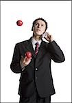 Businessman juggling while talking on phone