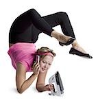 Female contortionist talking on phone and ironing