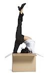 Female contortionist businesswoman inside cardboard box