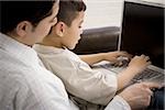 Father and young son working on laptop computer