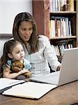Mutter und junge Tochter arbeiten auf Laptop-computer