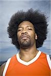 Basketball player with an afro in orange uniform