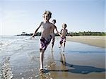 Drei Jungen spielen am Strand