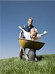 Father pushing son in a wheelbarrow