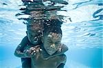 Boys swimming underwater in pool