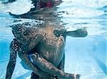 Boys swimming underwater in pool