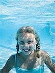 Girl swimming underwater in pool