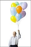 Older man holding balloons