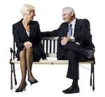 Businessman and businesswoman sitting on a bench