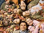 Young girls playing in pile of fallen leaves