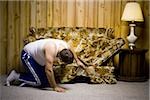 Man looking under sofa cushion