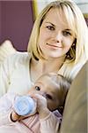 Woman holding baby with bottle