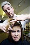 Woman having hair cut by hairdresser