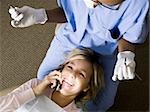 Girl with dental hygienist talking on cell phone