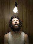 Man looking up at light bulb