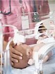 Baby in incubator with female nurse