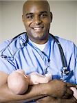 Male nurse or doctor holding newborn baby