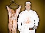 Butcher with hanging carcass and knife