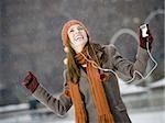 Woman with mp3 player outdoors in winter smiling