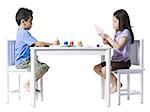 Boy and girl sitting at table doing crafts