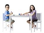 Boy and girl sitting at table doing crafts