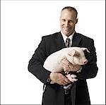 Businessman holding briefcase and piglet