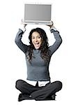 Woman sitting cross legged with laptop smiling