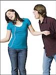 Girl listening to mp3 player with boy yelling