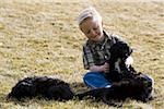 Garçon avec des chiots à l'extérieur