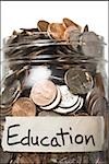 Detailed view of glass jar with coins and Savings label