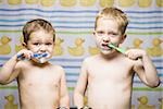 Two boys brushing teeth in bathroom sink