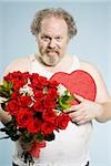 Homme échevelé avec roses rouges et le sourire de la boîte coeur