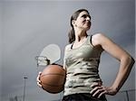 Woman holding basketball with net in background