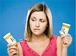 Woman holding two bottles of prescription capsules