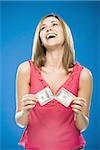 Woman tearing American hundred dollar bill smiling