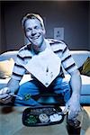 Man on sofa with frozen dinner and napkin with food smiling