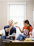 Man giving woman money both in football jerseys