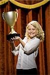 Girl holding trophy cup smiling