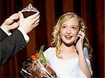 Beauty pageant winner smiling and holding roses
