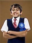 Boy with first place ribbon and arms crossed smiling