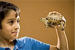 Boy holding turtle smiling
