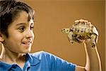 Boy holding turtle smiling