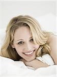 Woman lying down in bed smiling