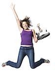 Girl with electric guitar jumping and smiling with arm up