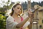 Woman smiling and taking a photograph outdoors