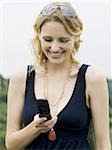 Woman with cell phone outdoors smiling