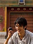 Teenage boy outdoors with cell phone smiling