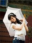 Teenage girl outdoors with umbrella smiling