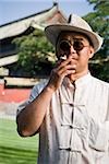 Man with sunglasses smoking cigarette outdoors